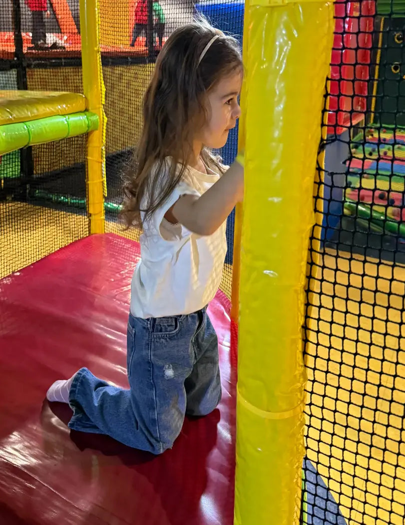 Child playing in a colorful indoor playground.