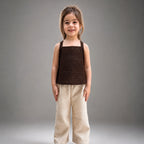 Young girl wearing a brown top and beige pants against a gray background