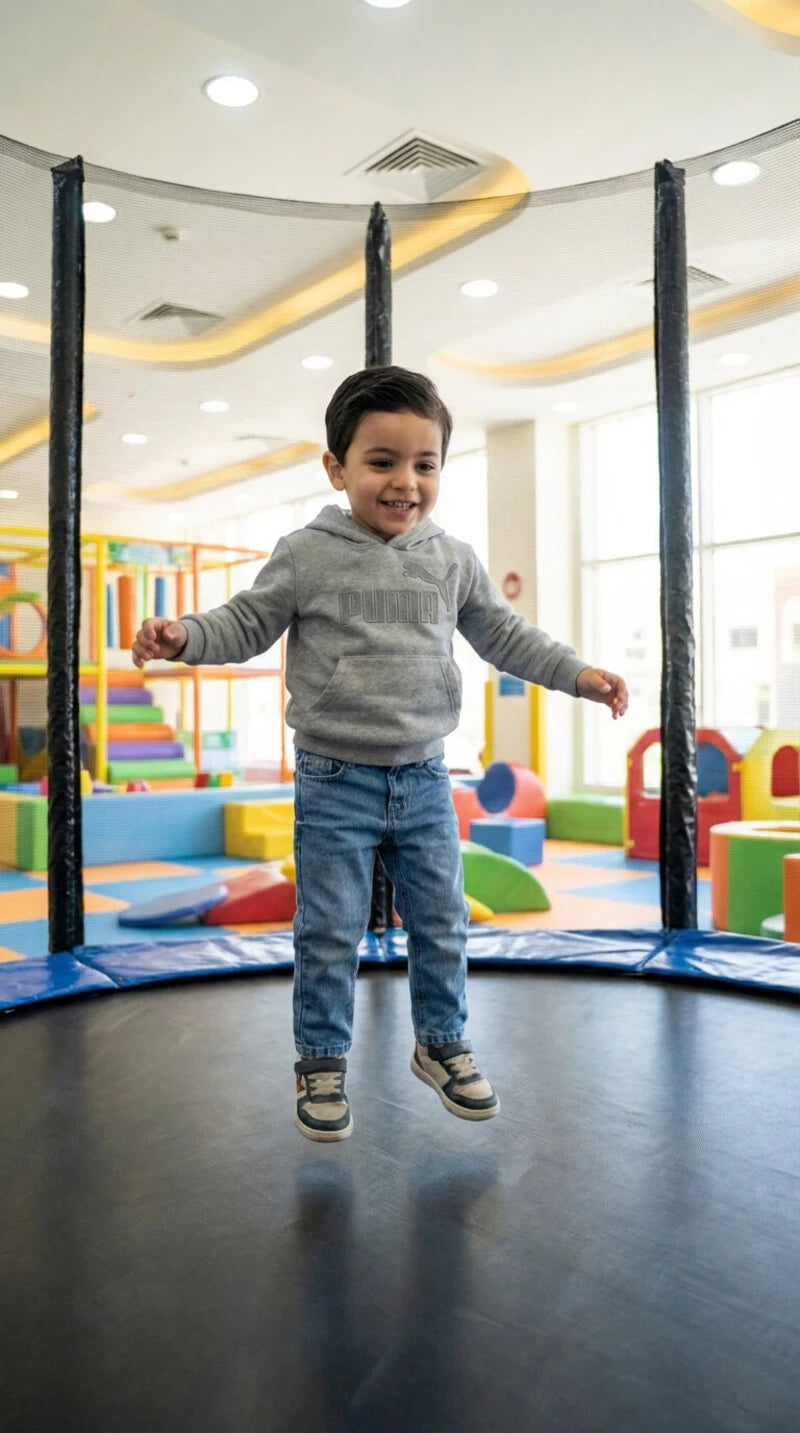 Child jumping in a play area with colorful equipment