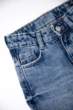 Close-up of blue denim jeans on a white background