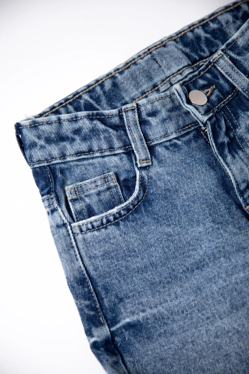 Close-up of blue denim jeans on a white background