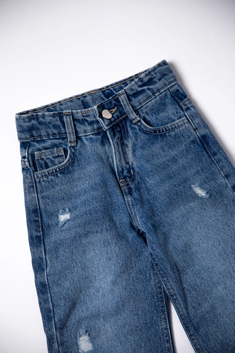 Blue jeans with slight distressing on a white background